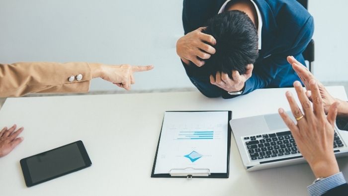 employee holding his head,